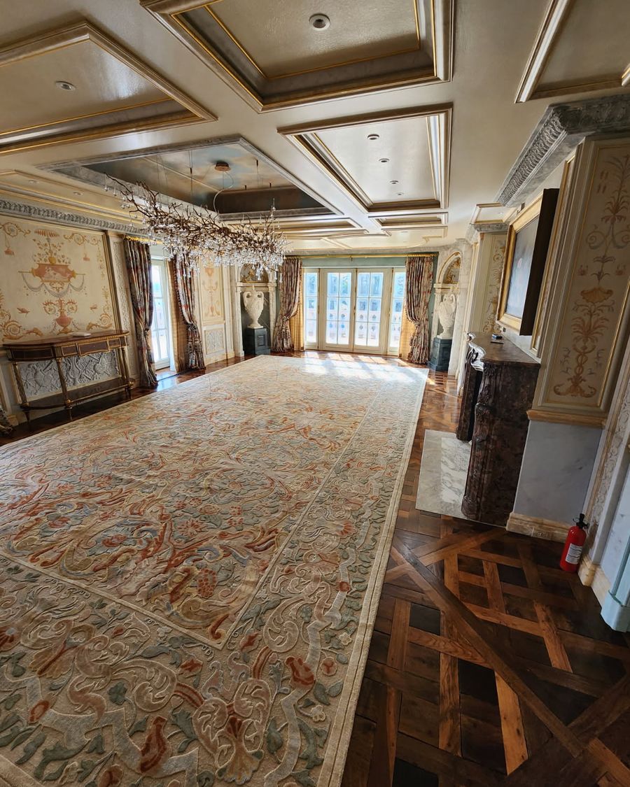 Formal room in a Pellikal client's home with a large antique rug, framed artwork and parquet flooring beside tall glazed doors